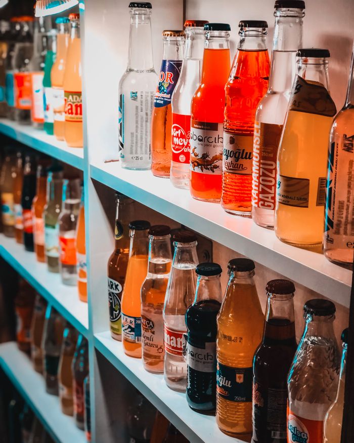 A colorful variety of beverage bottles lined up on a shelf for display.