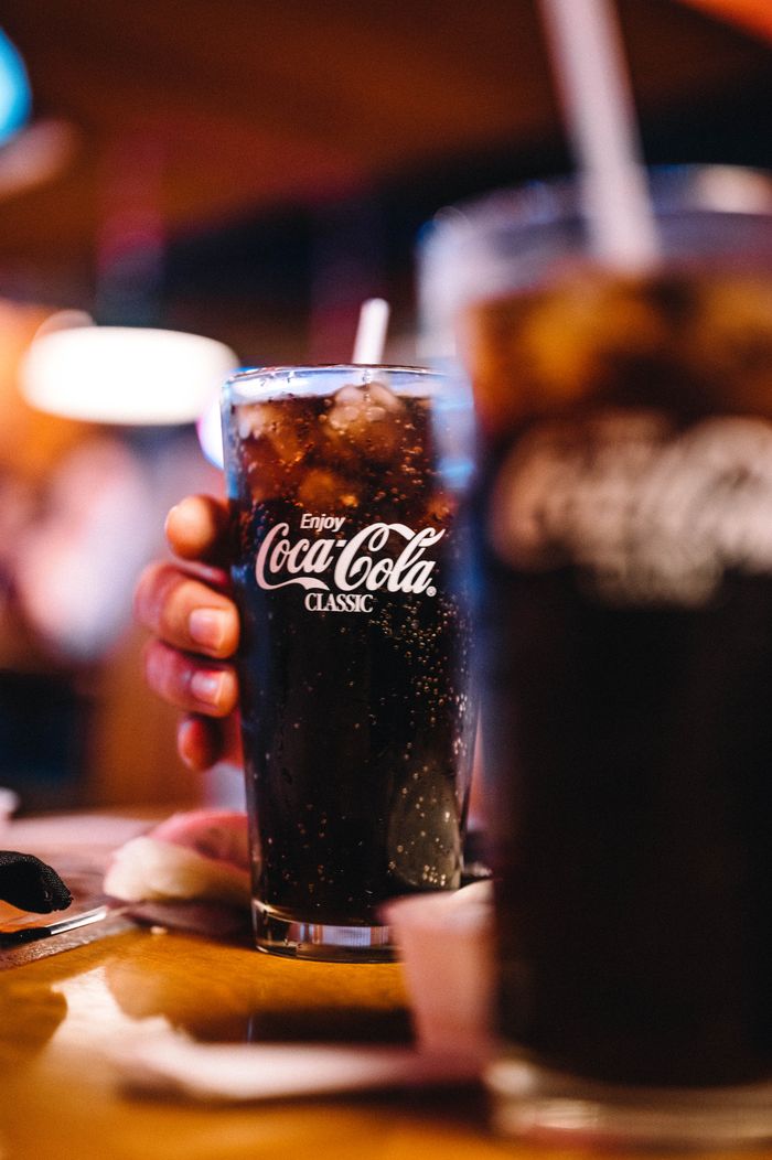 Close-up of a refreshing Coca-Cola Classic served cold in a glass with ice.