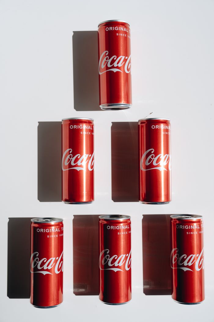 Artistic arrangement of Coca-Cola cans creating a geometric pattern.